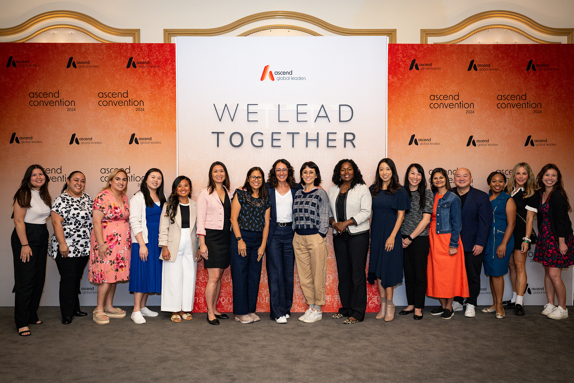 A group of Disney employees and talent standing in front of a backdrop with the title We Lead Together.