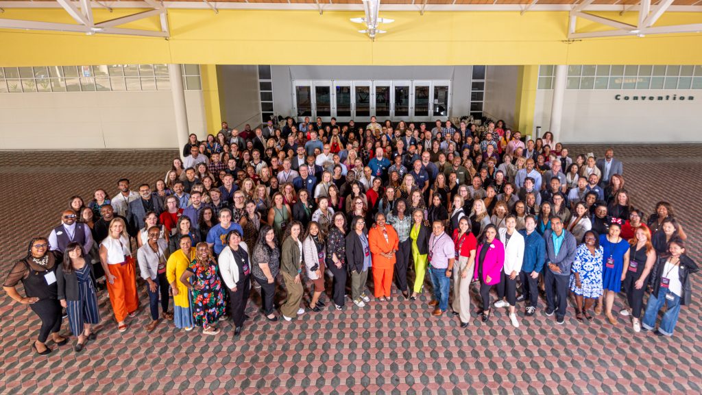 A group of employees from The Walt Disney Company standing outside of a convention center.