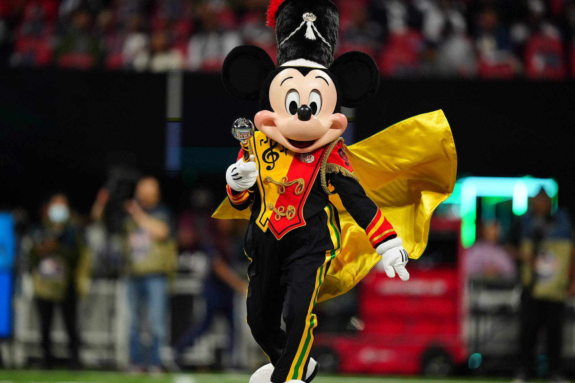 Drum Major Mickey walking on the field at a college football game.